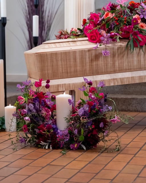 Sarg mit Blumenschmuck und Kerzen in der Trauerhalle Bramfeld